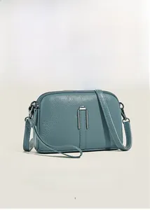 Detail view of teal lychee grain leather crossbody bag with silver U-shaped metal hardware