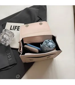 Detail view of pink leather crossbody bag interior showing spacious storage for phone and umbrella