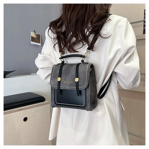 Detailed view of the vintage leather texture and gold stud accents on the stylish backpack