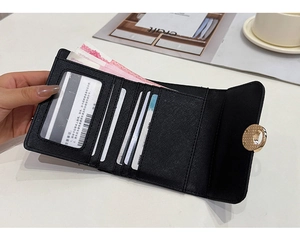 Detail of black cross-grain leather tri-fold wallet with multi-card slots and gold lock