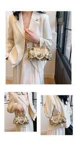 Details einer goldenen Pailletten-Handtasche mit Perlenkette und Metallgriff im Fokus