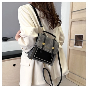 Detail of dark grey patchwork backpack with silver rivets and fashion text logo