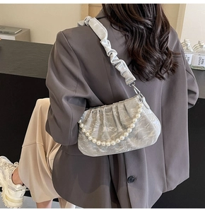 Détail du sac plissé avec motif marbré, poignée en perles et bandoulière froncée