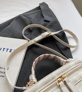 Detail of cream bucket bag featuring marble texture and silk scarf wrapped handle