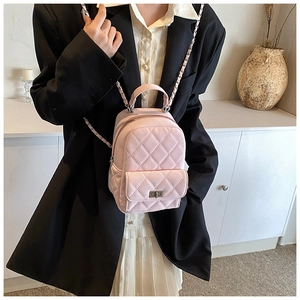 Detail of pink quilted leather mini backpack with metal chain straps and turn-lock
