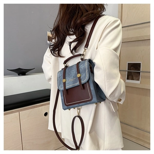 Close-up of minimalist patchwork denim backpack with leather trim on model's back
