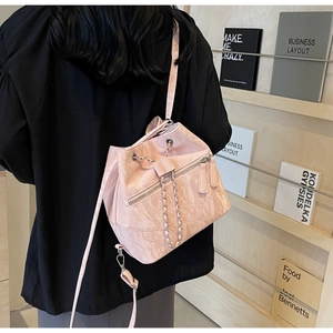 Close-up of pink bucket bag with pleated PU leather texture and silver chain strap details
