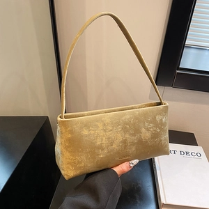 Minimalist bronze metallic baguette shoulder bag with Clear UK logo on a textured surface