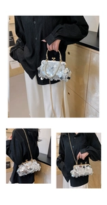 Detail der silbernen Pailletten-Abendtasche mit Perlengriff und Goldkette