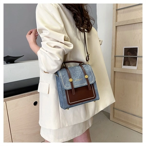 Detail showing retro blue and brown leather stitching on a stylish crossbody bag