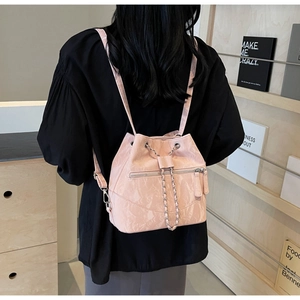 Detail view of pink marble pattern bucket bag with silver chain worn by a model