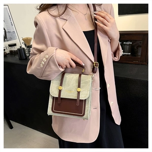 Chic beige canvas and brown leather crossbody bag styled with a pink suit and black skirt