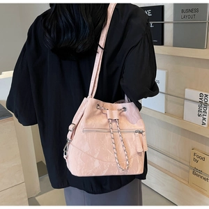 Detail of pink marble textured bucket bag with chain drawstring and zipper on model