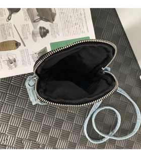 Dettaglio dell'interno in tessuto nero e della cerniera argentata della borsa in denim