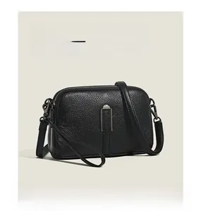 Close-up of black litchi grain leather texture and silver vertical metal hardware detail