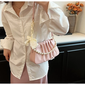 Detail der rosa gerafften Cloud-Tasche mit Perlenkette und cremefarbener Satinschleife