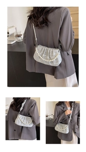 Detail of light blue marble cloud bag featuring elegant pearl chain and pleated texture