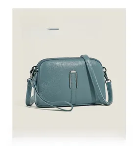 Close-up of blue lychee-textured leather crossbody bag with silver U-shaped metal hardware