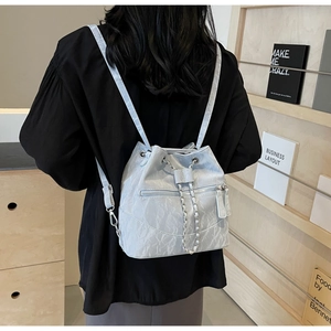 Detail of light blue wrinkled PU leather bucket backpack with silver chain and drawstring