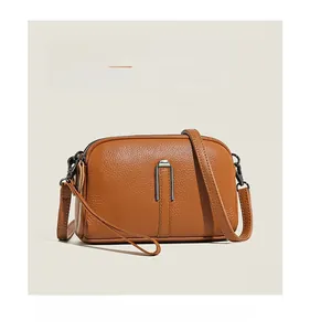 Detail of brown litchi pattern leather texture and dual zipper hardware on camera bag