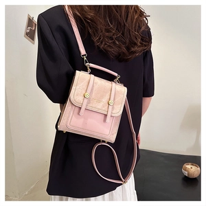 Detail of pink and beige patchwork bag with metal rivets and elegant shoulder strap