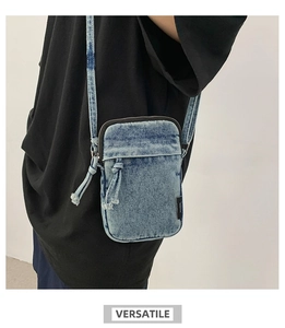 Dettaglio borsa porta cellulare in denim azzurro con tasca a nodo e zip