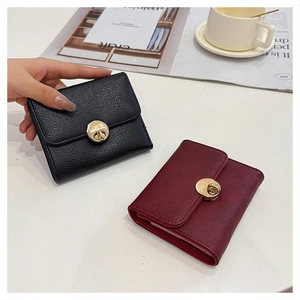 Detailed view of lychee pattern leather wallets in black and wine red with gold locks