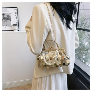 Detail einer goldenen Pailletten-Abendtasche mit Perlengriff und Metallkette