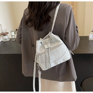 Detail showing pleated silver bucket bag with chain accent and drawstring closure