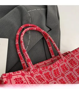 Detail of red wedding tote bag handles and thick fabric with Double Happiness pattern