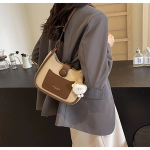 Détail du sac hobo crème et marron avec bandoulière réglable et breloque peluche