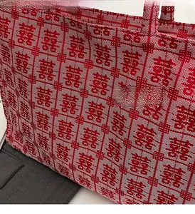 Detail of red and white woven canvas tote bag featuring traditional double happiness patterns