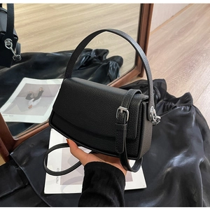 Close-up of black lychee texture leather bag with silver buckle and flip-top design