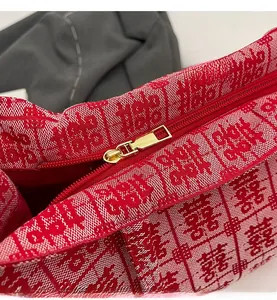 Detail of high-quality smooth metal zipper on red woven festive bridal tote bag