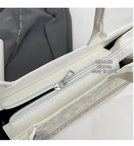 Detailed close-up of the smooth silver zipper and interior lining of this tote bag