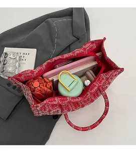 Spacious interior of red canvas tote with double happiness pattern holding daily items