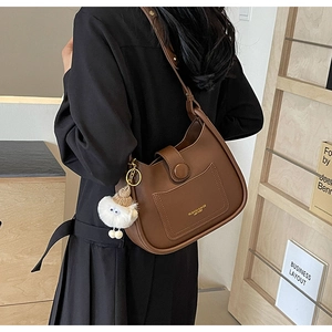 Vue détaillée du sac seau marron en similicuir avec charme peluche et poche à rabat