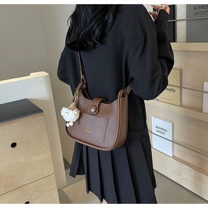 Détail du sac hobo marron café avec texte doré et pendentif en peluche mouton blanc