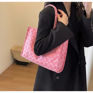 Close-up of bright pink canvas tote bag with red Double Happiness patterns worn by model