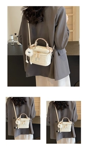 White quilted vanity case with silk-wrapped handle and pom-pom detail on model