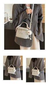 Detail view of light grey box bag with pleated PU leather, silk scarf, and plush charm