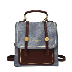 Vintage style blue denim and brown leather backpack with gold rivets and handle