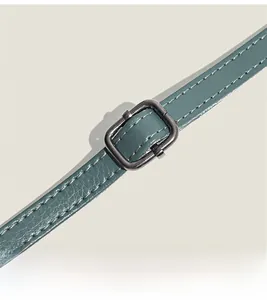 Detailed close-up of dark green lychee grain leather strap with adjustable metal buckle