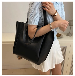 Side view of woman wearing a large black minimalist tote bag for daily commute
