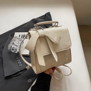 Elegant cream bow backpack with pleated texture and silver hardware for women