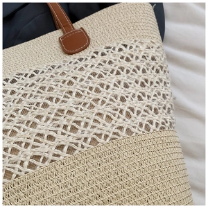 Détail d'un sac en paille tressée beige avec poignée en cuir brun et texture mesh
