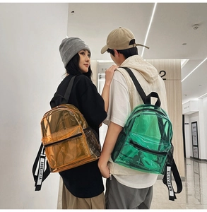Close-up of stylish transparent PVC backpacks in bright orange and green with black straps