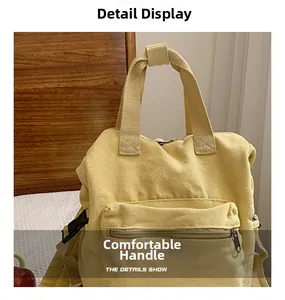 Close-up of bright yellow canvas backpack featuring reinforced top handle and snap fastener