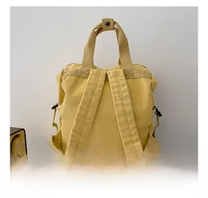 Detail of comfortable wide shoulder straps on yellow canvas backpack for students