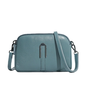 Dusty blue crossbody bag in lychee pattern leather with stylish white contrast stitching